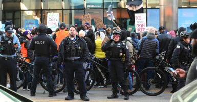 Demonstrators hold up signs as they are surrounded by police during a protest in Chicago.