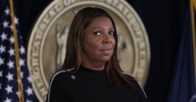 Letitia James, in a black sweater looks side-eyed at the camera.