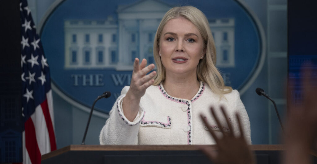 Karoline Leavitt points to reporter from White House podium.