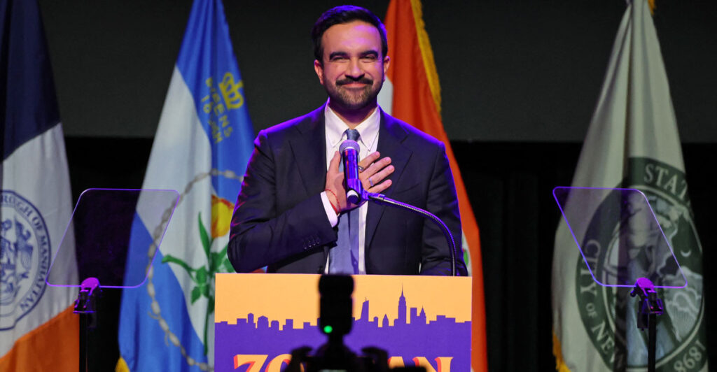 Zohran Mamdani, with hand on heart looks out during victory speech.