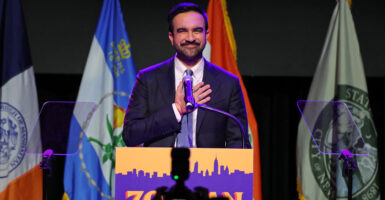 Zohran Mamdani, with hand on heart looks out during victory speech.