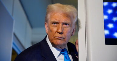 Donald Trump leans against a door frame on Air Force One.