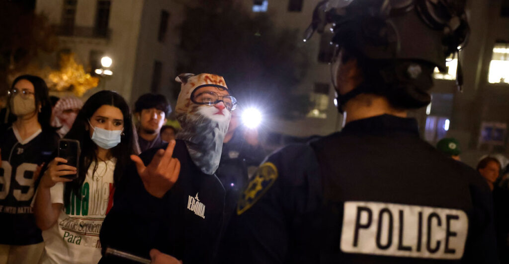 Leftist protesters including someone in furry mask confront police.