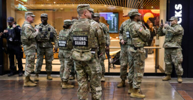 Members of the National Guard in camouflage uniforms stand in Union Station.