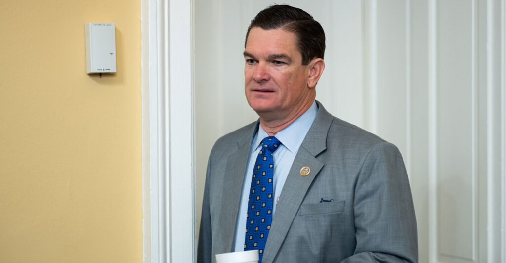 Austin Scott holds a cup of coffee in the house rules committee.