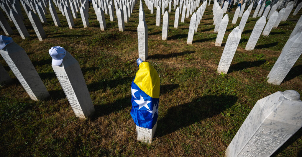A gravestone is covered with the flag of Bosnia and Herzegovina.