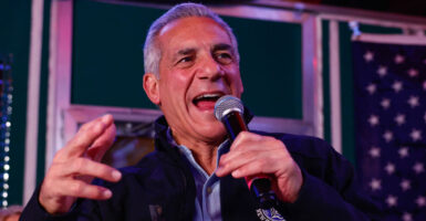 Republican Jack Ciattarelli stands holding a microphone.