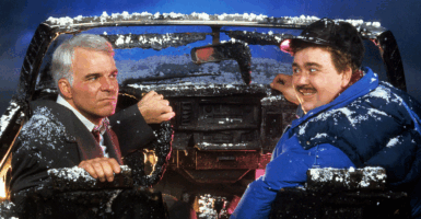 Steve Martin and John Candy sit in a destroyed car in a scene from the film 'Planes, Trains & Automobiles', 1987.