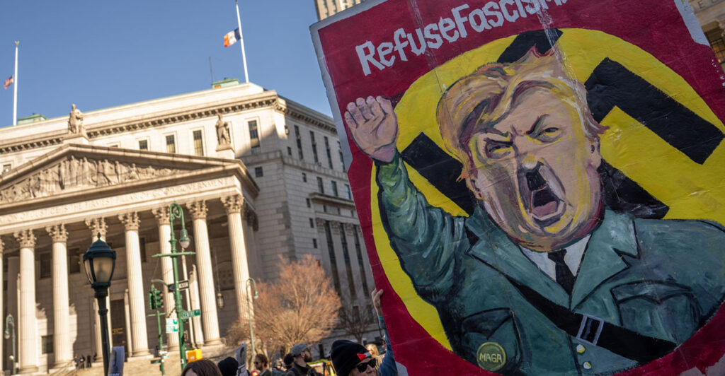 NEW YORK, NEW YORK - MARCH 10: Protestors hold a sign depicting President Donald Trump as Adolf Hitler during a rally to demand the release of Mahmoud Khalil at Foley Square on March 10, 2025 in New York City. Mahmoud Khalil, a Columbia University graduate and Palestinian activist arrested Saturday, received a temporary reprieve from deportation. A federal judge in New York blocked the Trump administration's efforts to deport him until a conference on Wednesday. (Photo by David Dee Delgado/Getty Images)