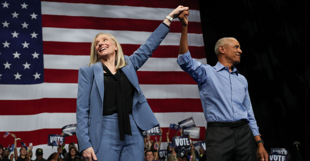 Former U.S. President Barack Obama (R) and Virginia Democratic gubernatorial candidate, former Rep. Abigail Spanberger raise their arms together during a campaign rally.