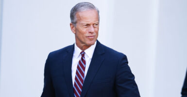 Senate Majority Leader John Thune, dressed in a suit, exits the White House.