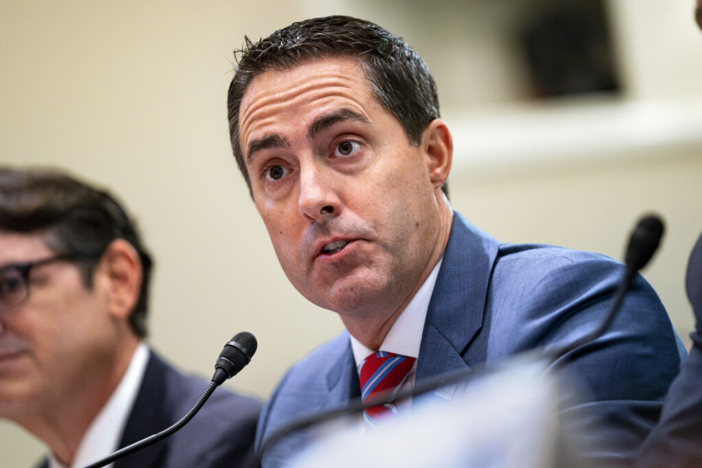 Ohio Secretary of State Frank LaRose speaks at a microphone from his seat.