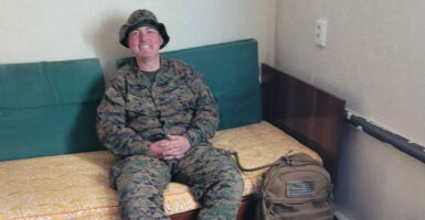 Marine vet Thomas Harris in uniform, seated and smiling.