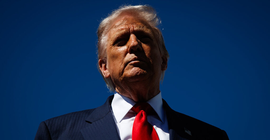 Close up of Donald Trump against a blue sky.