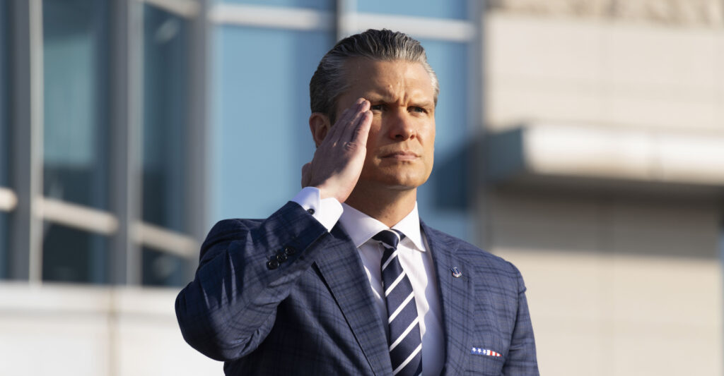 U.S. War Secretary Pete Hegseth salutes as he inspect a guard of honor