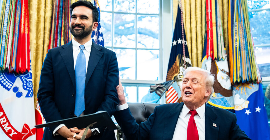 Zohran Mamdani stands next to a seated and jovial Donald Trump in the Oval Office.