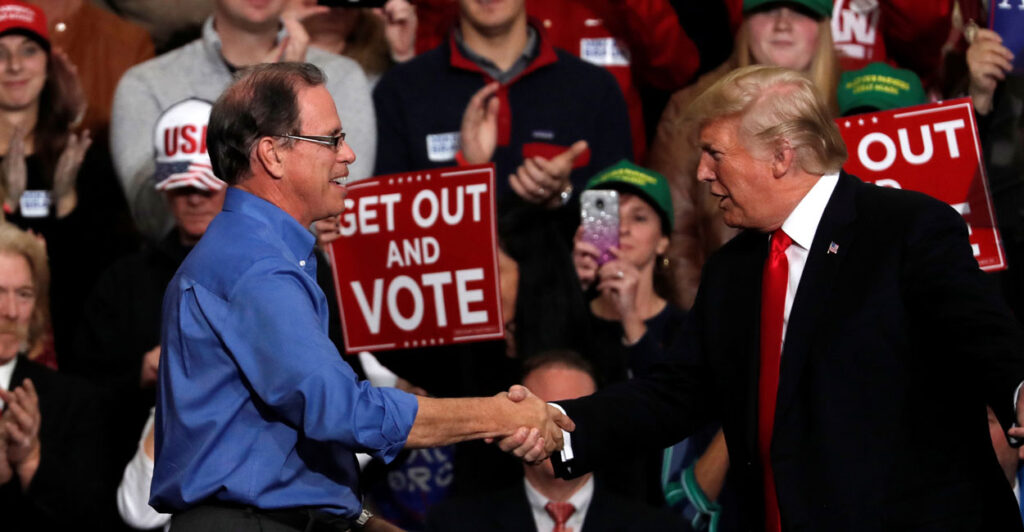 President Donald Trump shakes hands with Mike Braun during a campaign rall.