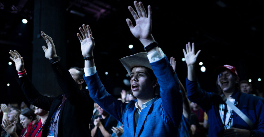 Attendees pray during AmericaFest