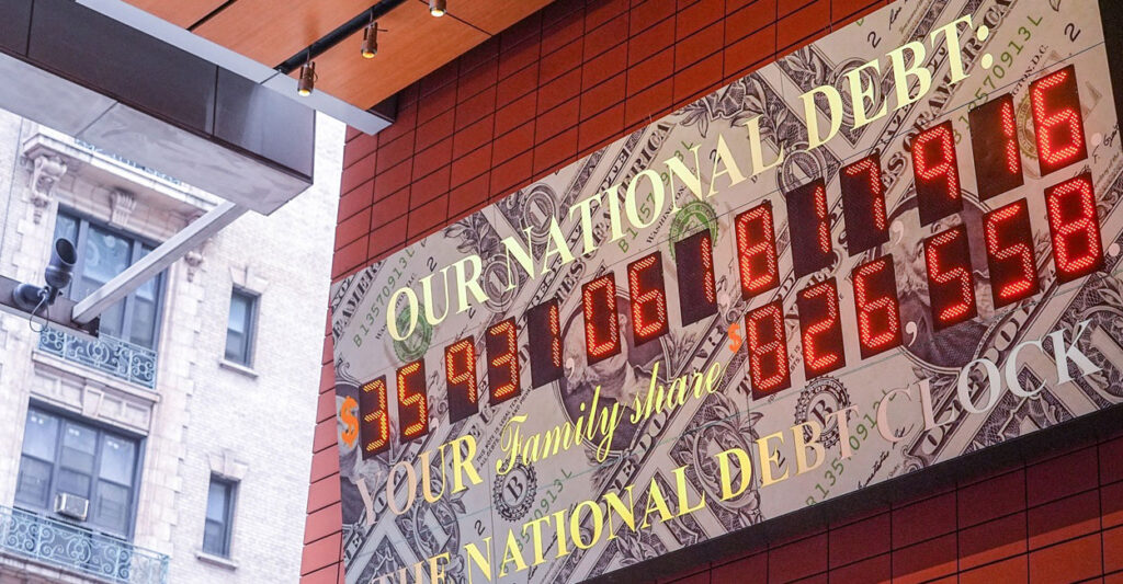 A federal debt clock hangs on a wall.