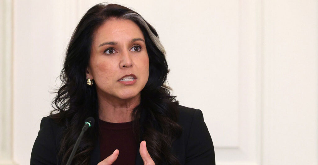 Tulsi Gabbard speaks at an event and gestures with both of her hands in front of her.