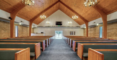 The inside of a church is shown with a viewpoint from the back looking forward.