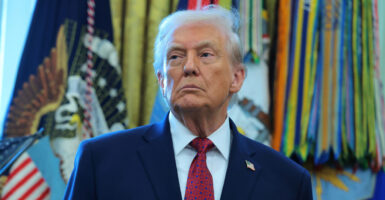 Donald Trump stands during a press conference and looks to his right.