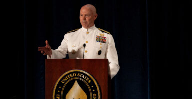 U.S. Navy Admiral Frank "Mitch" Bradley delivers remarks against a black background.