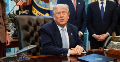 President Trump speaks to reporters from his desk in the Oval Office.