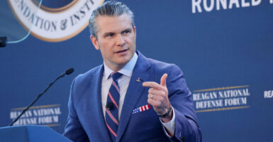 Pete Hegseth speaks while in a blue suit and blue, white and red tie.