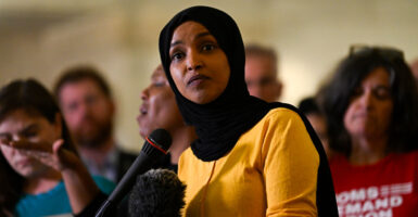 Ilhan Omar in a yellow blouse.