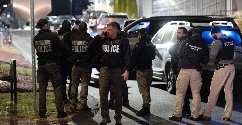 Law enforcement gather on street.