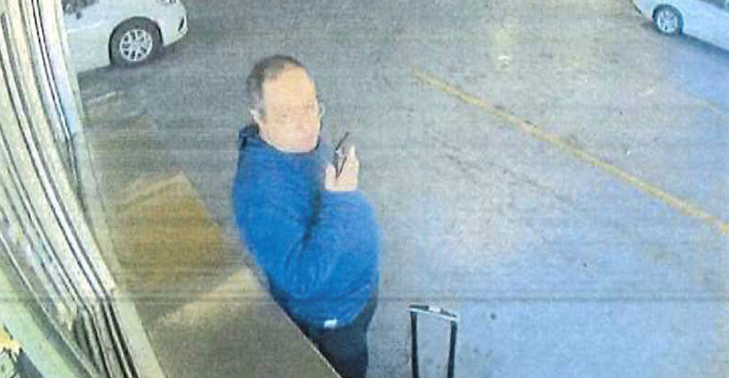 Claudio Manuel Neves Valente, suspect in the Brown University shooting in Providence, holds up a cellphone while picking up a vehicle at an Alamo Rent a Car.