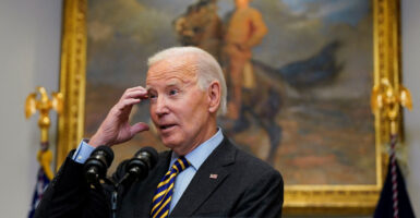 Joe Biden with his right hand at his forehead.