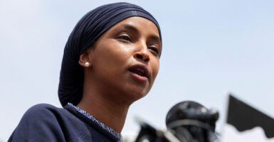 Close-up of Ilhan Omar in black speaking at a rally.