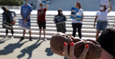 Pro-lifers stand outside the U.S. Supreme Court, as one holds a fetal model.