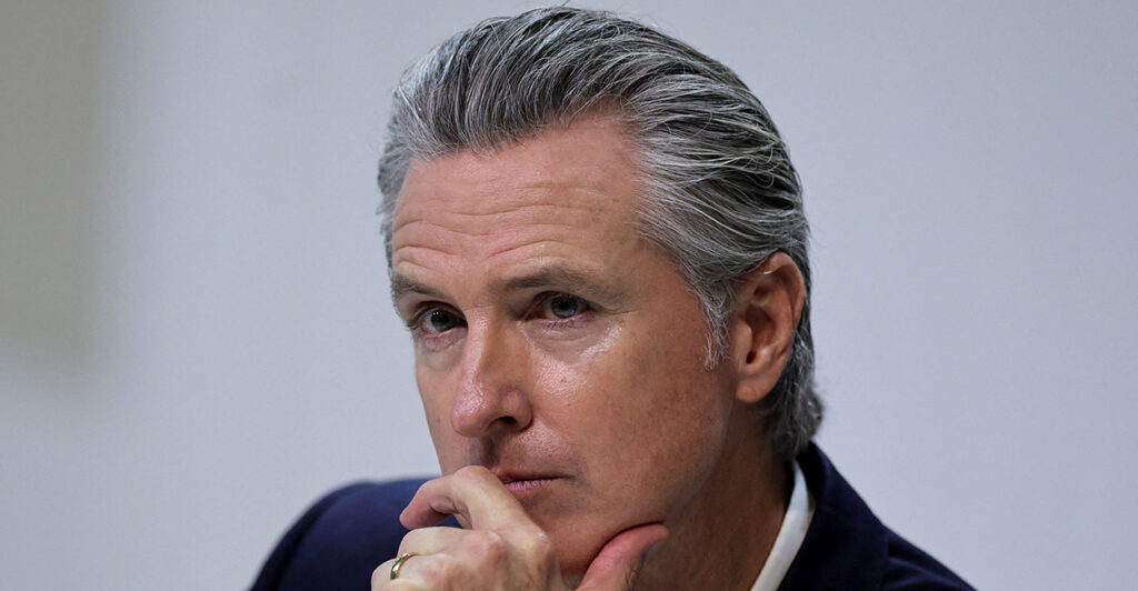 Close-up of Gavin Newson resting his chin in his hand. A federal judge issued a class-wide injunction blocking school districts from requiring teachers to hide students' gender identities from parents, in a blow to Gov. Gavin Newsom's transgender secrecy policy.