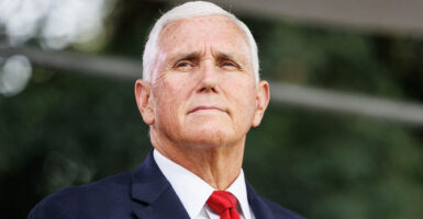 Mike Pence stands outside in a suit and tie.