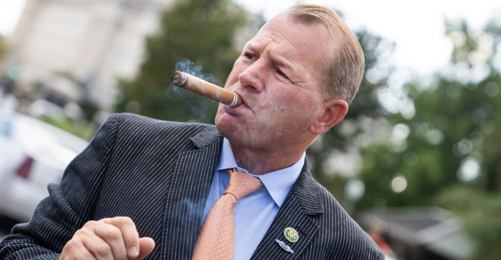 Congressman Troy Nehls smokes a cigar in front of the capitol.