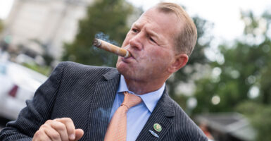 Congressman Troy Nehls smokes a cigar in front of the capitol.