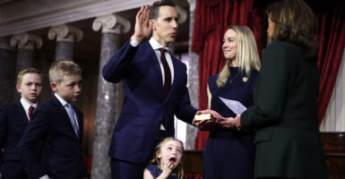 Sen. Josh Hawley is sworn in, as his wife holds the Bible and daughter makes a face.