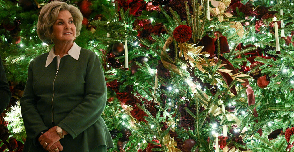 Susie Wiles poses next to a beautiful Christmas tree.