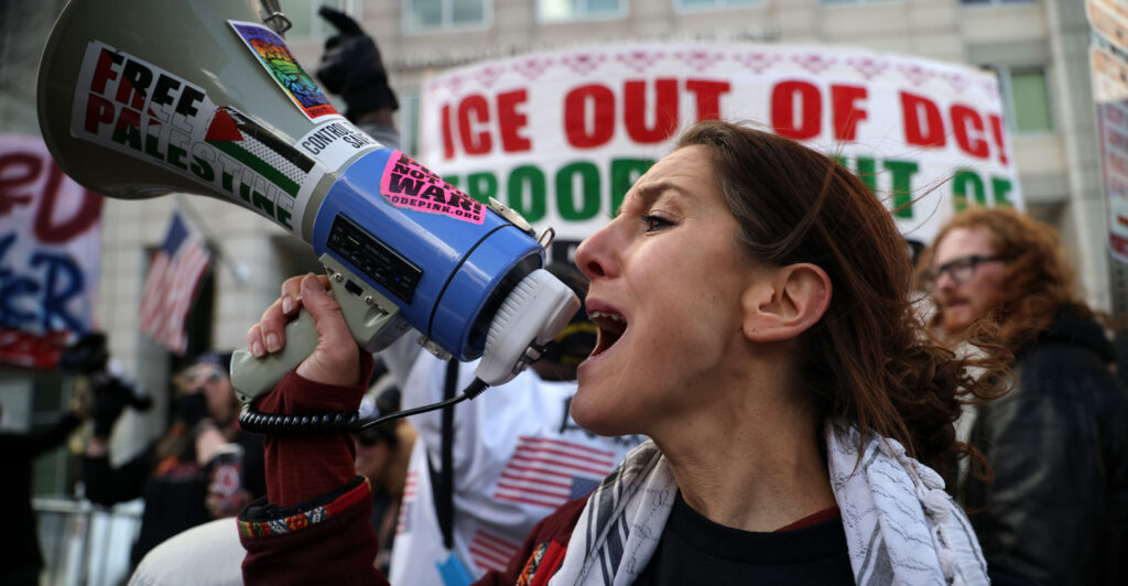 WASHINGTON, DC - JANUARY 11: An activist shouts slogans as she participates in a protest outside the headquarters of U.S. Immigration and Customs Enforcement (ICE) on January 11, 2026 in Washington, DC. Protests have broken out across the nation over the Trump administration’s recent actions in Venezuela and the shooting death last week of Renee Good by an Immigration and Customs Enforcement (ICE) officer in Minneapolis, Minnesota. (Photo by Alex Wong/Getty Images)