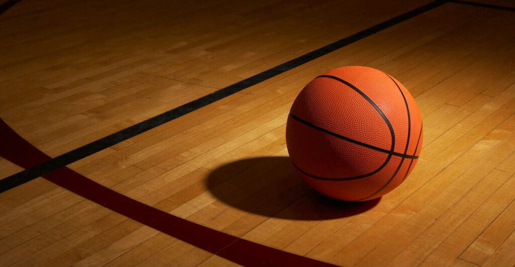 A basketball rests on a basketball court.