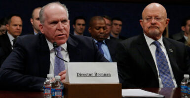 Then-Director of National Intelligence James Clapper watches then-CIA Director John Brennan speaks during a congressional hearing.