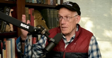 Victor Davis Hanson speaks into a microphone on his podcast set.