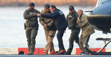Nicholas Maduro and his wife are led away in handcuffs from a helicopter by DEA agents