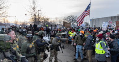 ICE agents clash with protesters on a street in Minneapolis.