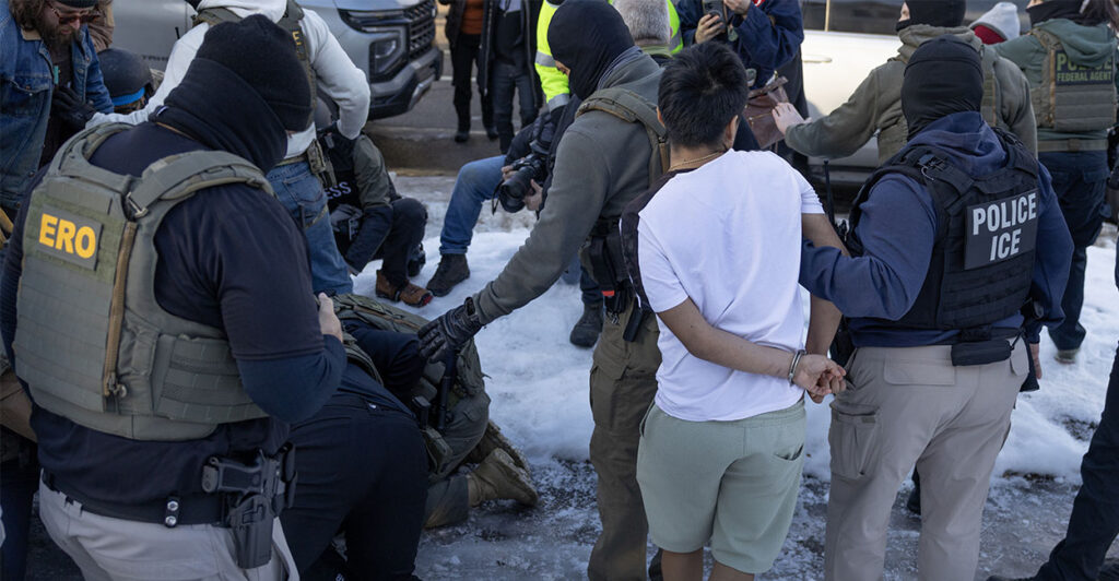 MINNEAPOLIS, MINNESOTA - JANUARY 13: Federal immigration agents clash with residents as they take a person into custody during a house raid on January 13, 2026 in Minneapolis, Minnesota. The Trump administration has sent an estimated 2,000 federal agents into the area, with more on the way, as they make a push to arrest undocumented immigrants in the region. (Photo by Scott Olson/Getty Images)