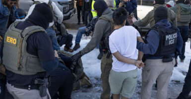 MINNEAPOLIS, MINNESOTA - JANUARY 13: Federal immigration agents clash with residents as they take a person into custody during a house raid on January 13, 2026 in Minneapolis, Minnesota. The Trump administration has sent an estimated 2,000 federal agents into the area, with more on the way, as they make a push to arrest undocumented immigrants in the region. (Photo by Scott Olson/Getty Images)