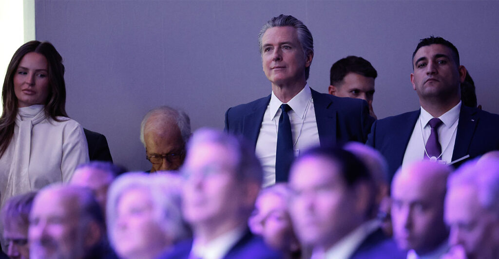DAVOS, SWITZERLAND - JANUARY 21: California Governor Gavin Newsom (C) listens to U.S. President Donald Trump address the World Economic Forum (WEF) in the Davos Congress Center on January 21, 2026 in Davos, Switzerland. The annual meeting of political and business leaders comes amid rising tensions between the United States and Europe over a range of issues, including Trump's vow to acquire Greenland, a semi-autonomous Danish territory. (Photo by Chip Somodevilla/Getty Images)